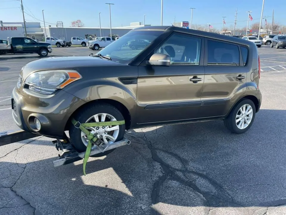 Junk car secured on a tow truck after being sold to an Indianapolis buyer