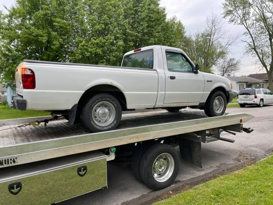 A white Ford Ranger secured on a flatbed on a residential Indianapolis street -- one phone call and a signature is the whole job
