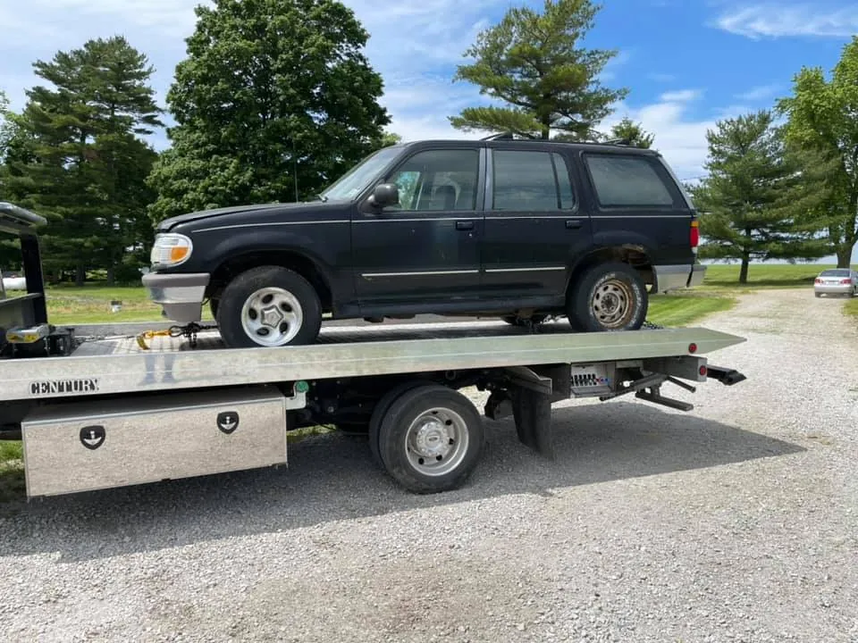 Black Ford Explorer SUV on a flatbed tow truck, a heavier vehicle that earns a stronger junkyard offer