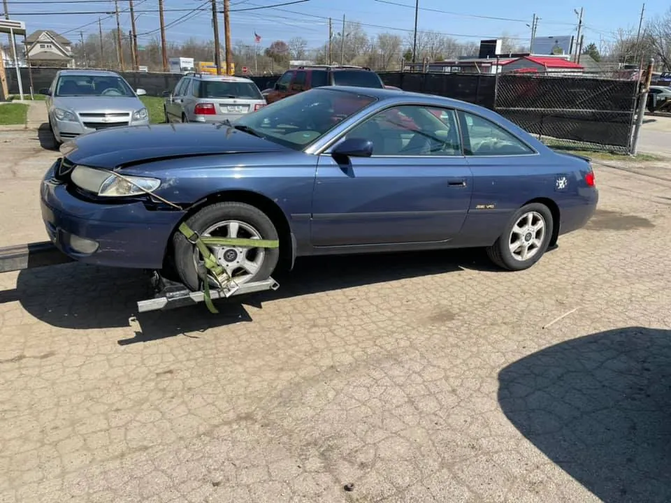 Damaged Toyota Camry Solara loaded for pickup, the type of salvage-titled vehicle Indiana buyers handle every day