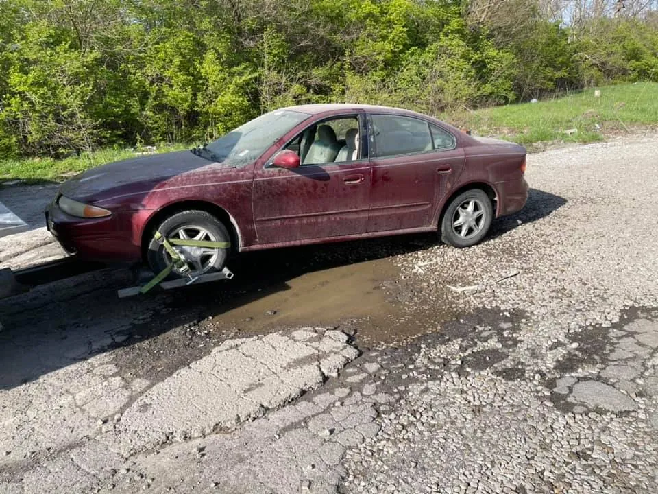 Driver's side collision damage on a red sedan -- frame and body damage reduce resale value but not parts value
